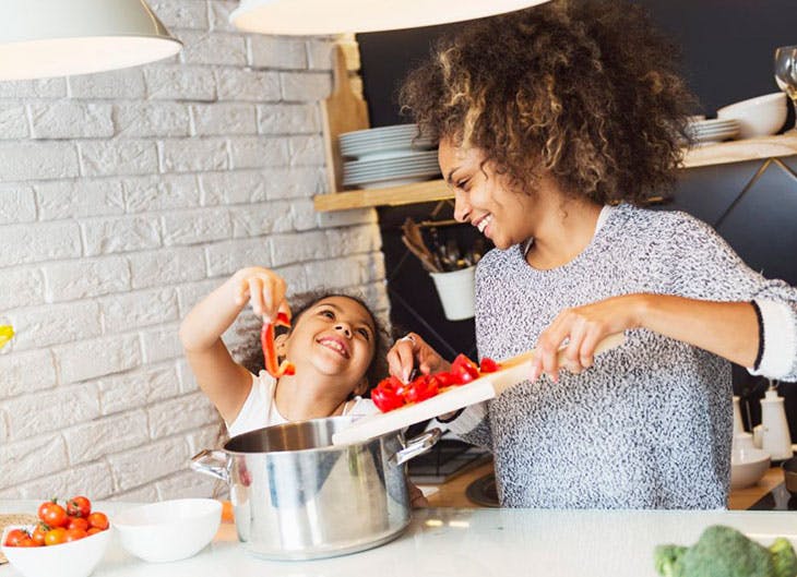 Madre e hija cocinando recetas saludables en la cocina