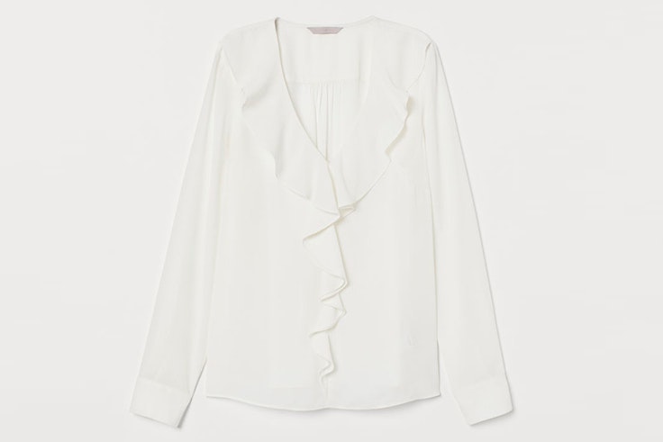 Blusa blanca con volantes en el escote de Sfera